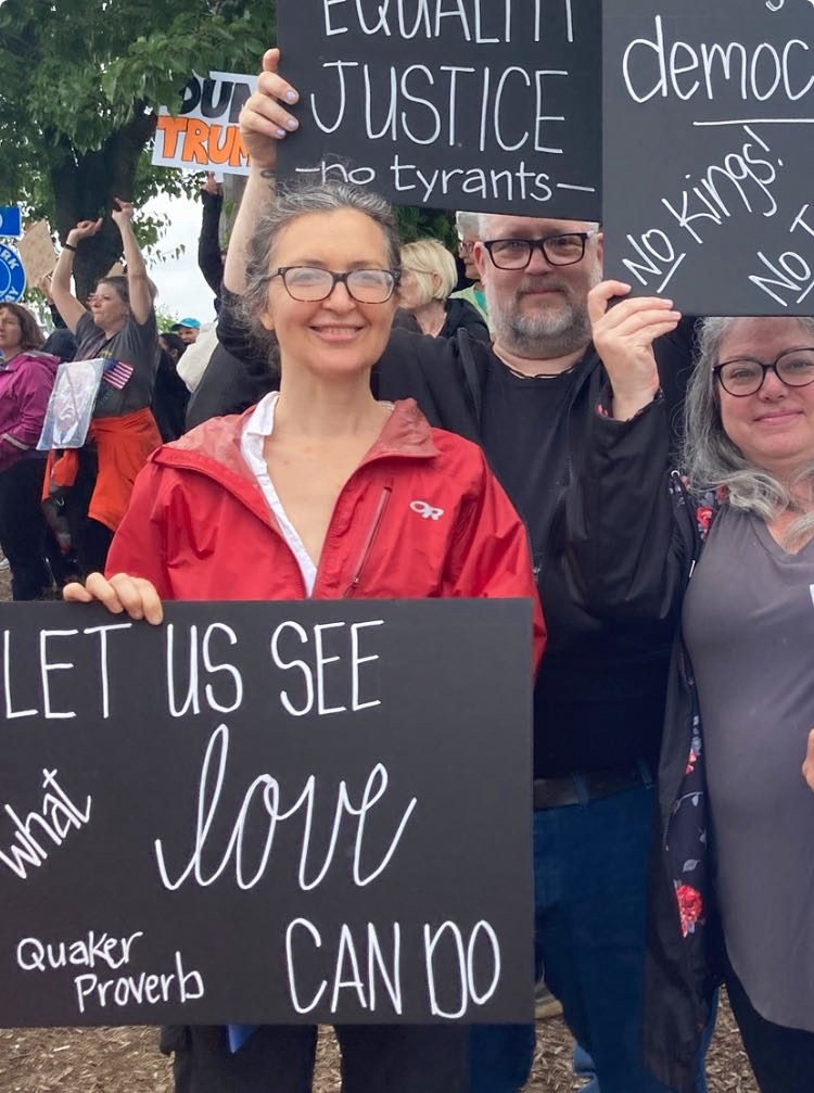 Sylke Jackson at a rally holding a sign that reads Let Us See What Love Can Do